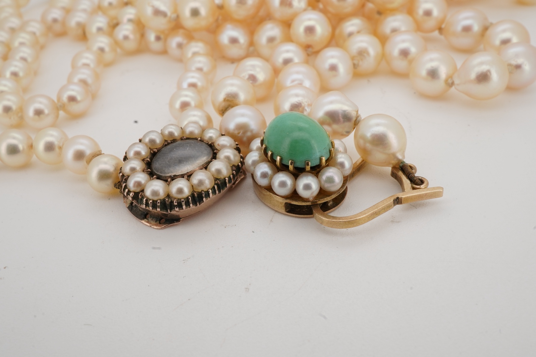 Two cultured pearl necklaces, comprising: one long strand of cultured pearls measuring approximately 7mm diameter, to a turquoise and cultured pearl clasp, length 86cm, clasp stamped 9ct; and a graduated cultured pearl n